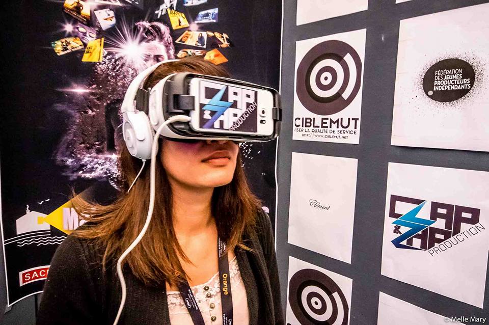 Visiteuse équipée d'un casque de réalité virtuelle sur le stand ClapZap Production.